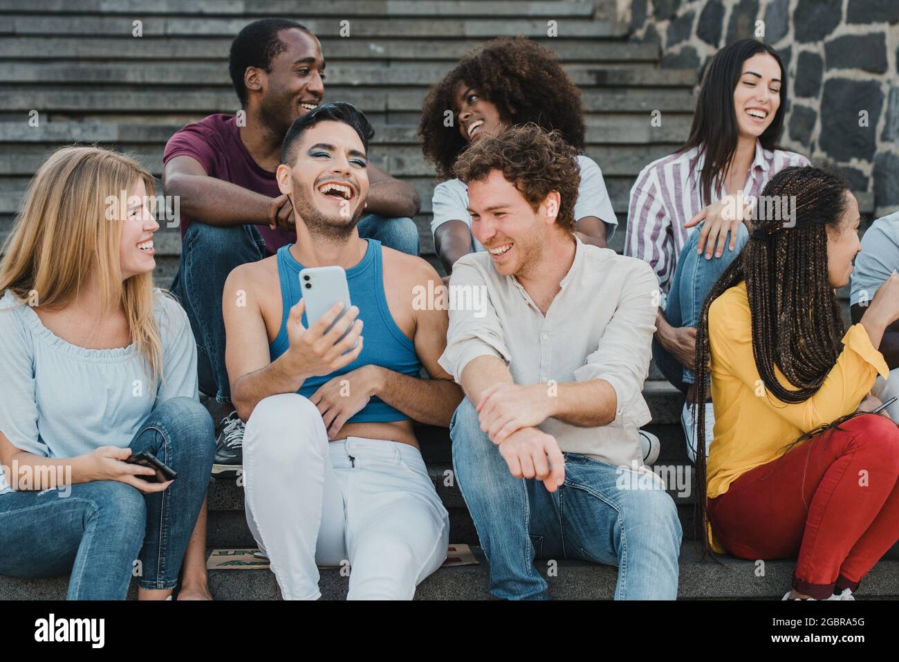 Junge Freunde haben Spaß mit Mobiltelefonen im Freien in der Stadt - Fokus auf Homosexuell Mann Gesicht Stockfoto