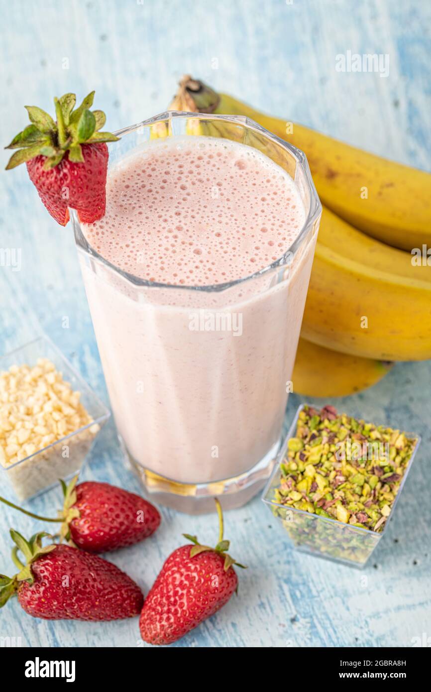 Kalter Erdbeer- und Bananenmoothie auf blauem Hintergrund Stockfoto