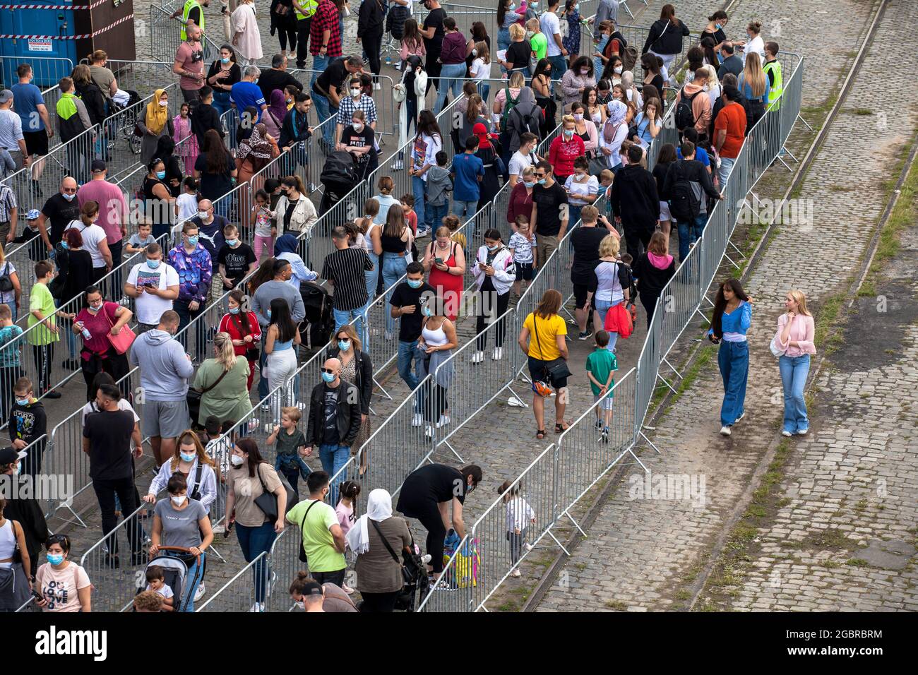 Leute, die in der Schlange stehen, Corona-konform, um den Jahrmarkt, den temporären Vergnügungspark Happy Colonia, am Ufer des Rheins in Deutz, C, zu betreten Stockfoto