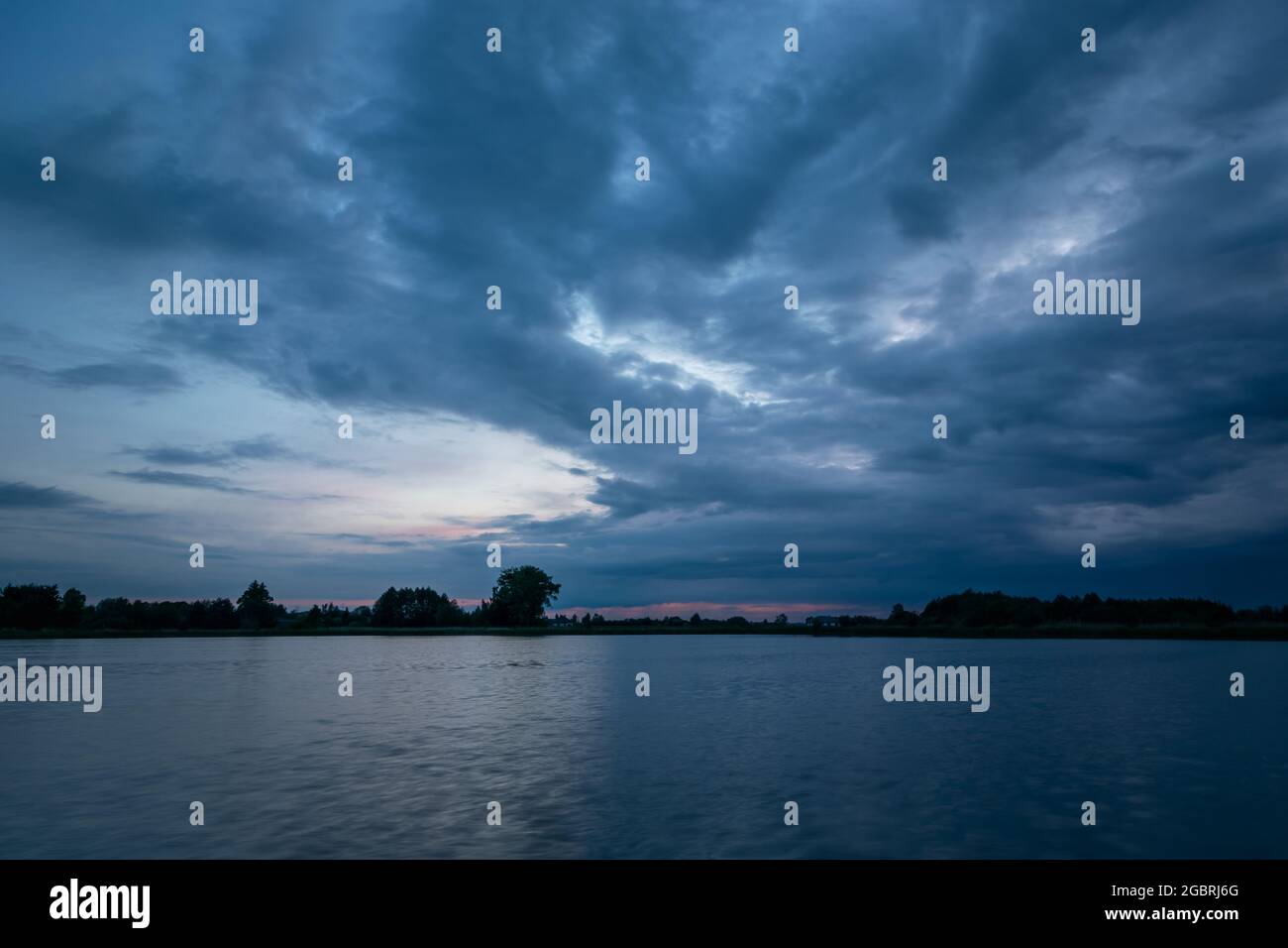 Wolkiger Abendhimmel über einem ruhigen See Stockfoto