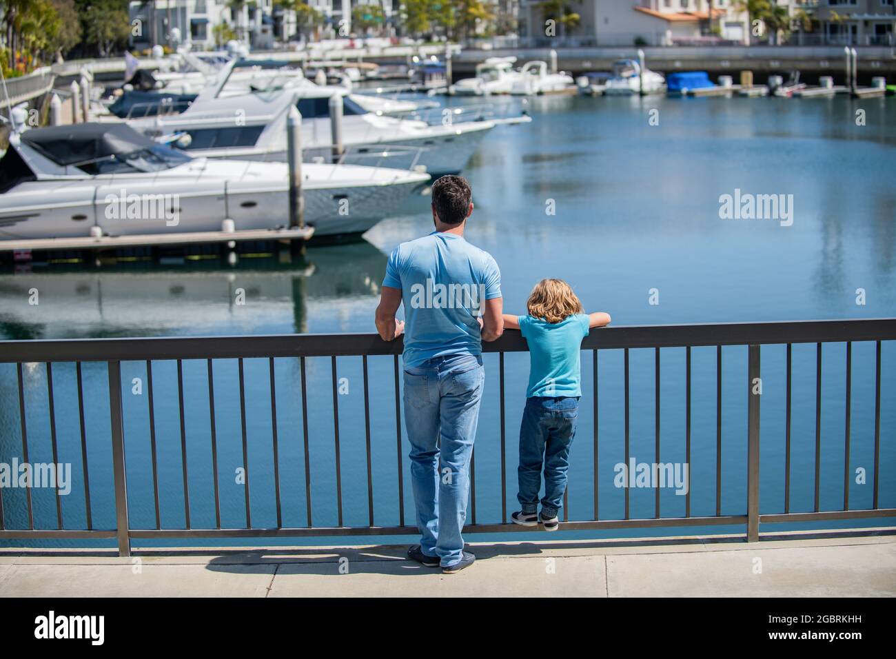 Elternschaft und Vaterschaft. Vatertag. Vater und Sohn blicken auf Yachten im Hafen. Stockfoto