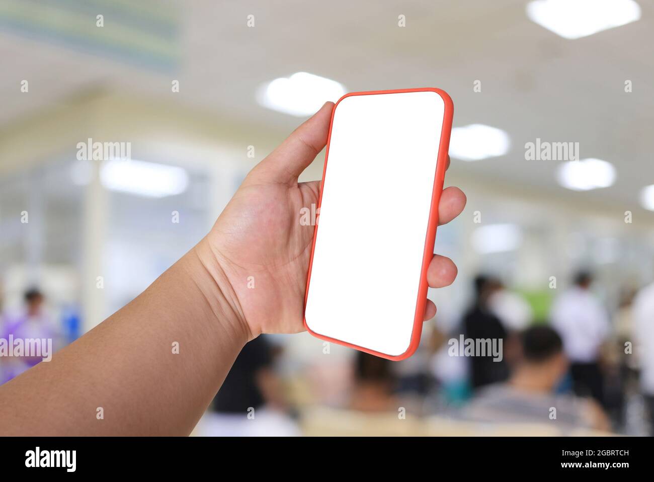 Handy in der Hand mit leerem Bildschirm auf Krankenhaushintergrund und haben Schnittpfade für Ihr Design. Stockfoto