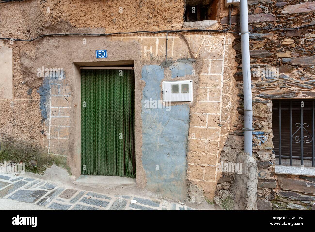 ROBLEDILLO DE GATA, SPANIEN - 27. März 2021: Robledillo de Gata, Spanien - 27. März 2021: Tür eines alten Hauses, das von Vorhängen geschützt ist, damit Insekten nichts tun Stockfoto