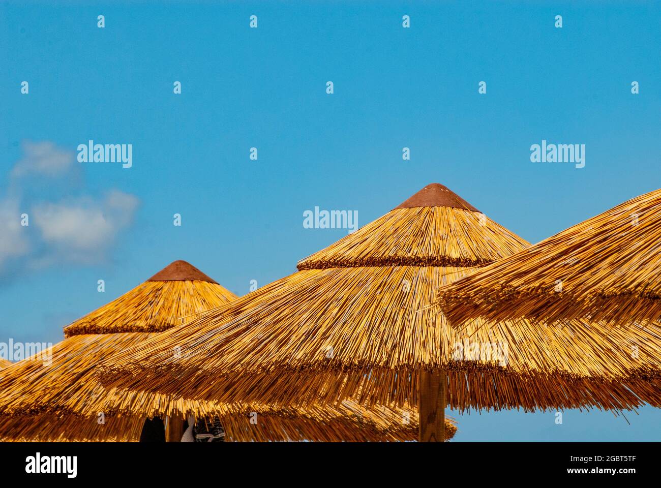 Stroh-Sonnenschirme vor smaragdgrünem Meer und weißem Sandstrand bei Ezzi Mannu im august 2021, Strand Pazzona, Sardinien, Italien, Europa Stockfoto
