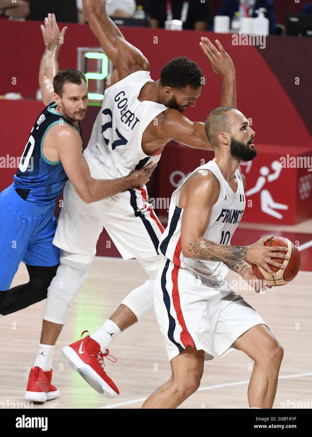Tokio, Japan. August 2021. Der Franzose Evan Fournier (R) dribbelt nach oben, als Teamkollege Rudy Gobert (27) während des Halbfinales der Männer im Basketball bei den Olympischen Spielen 2020 in Tokio am Donnerstag, den 5. August 2021, mit dem Slowenen Zoran Dragic zusammenstößt. Japan. Foto von Mike Theiler/UPI Credit: UPI/Alamy Live News Stockfoto