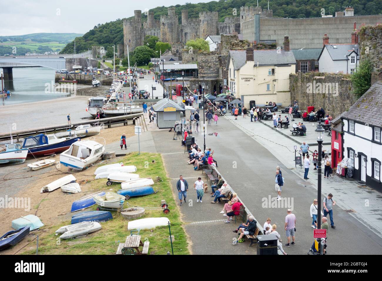 Conwy Hafen in Nordwales voller Touristen mit dem Schloss im Hintergrund Stockfoto