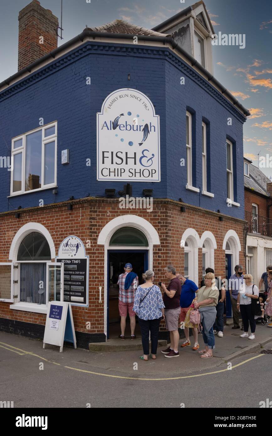 An einem Sommerabend, Aldeburgh Suffolk UK, stehen Menschen vor dem Aldeburgh Fish & Chip Shop Schlange, um Fisch und Chips zu kaufen Stockfoto