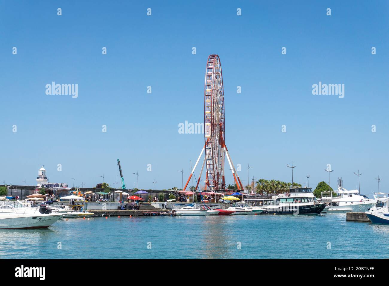 Batumi, Georgia - 2. Juli 2021: Batumi Coastline. Beliebte georgische Urlaubsstadt am Schwarzen Meer. Panoramablick auf das Riesenrad, den alphabetischen Turm, Wolkenkratzer und den Strand vom Meer aus. Stockfoto
