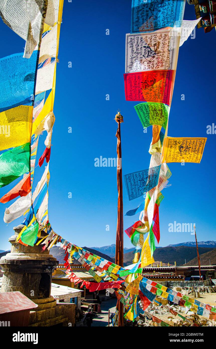 Bunte tibetische Gebetsfahnen, die Glück und Segen verbreiten, hängen an der Wand des Klosters. Stockfoto