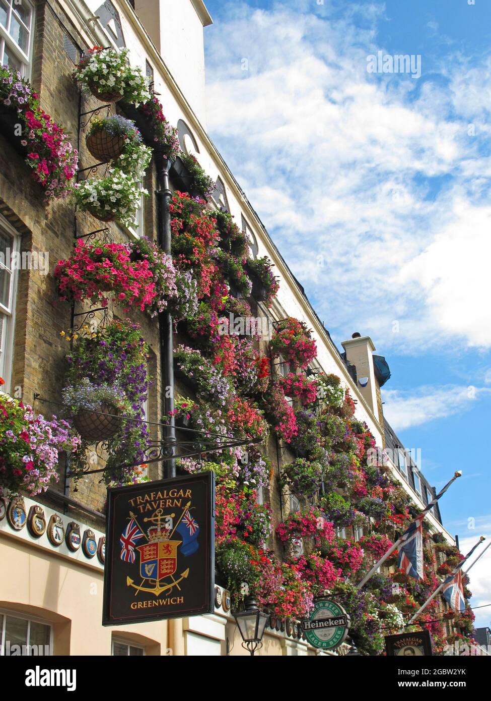Mehrere Blumenkörbe hängen an der Wand des Trafalgar Pub in Greenwich, dem historischen Flussviertel östlich von London, Großbritannien. Stockfoto