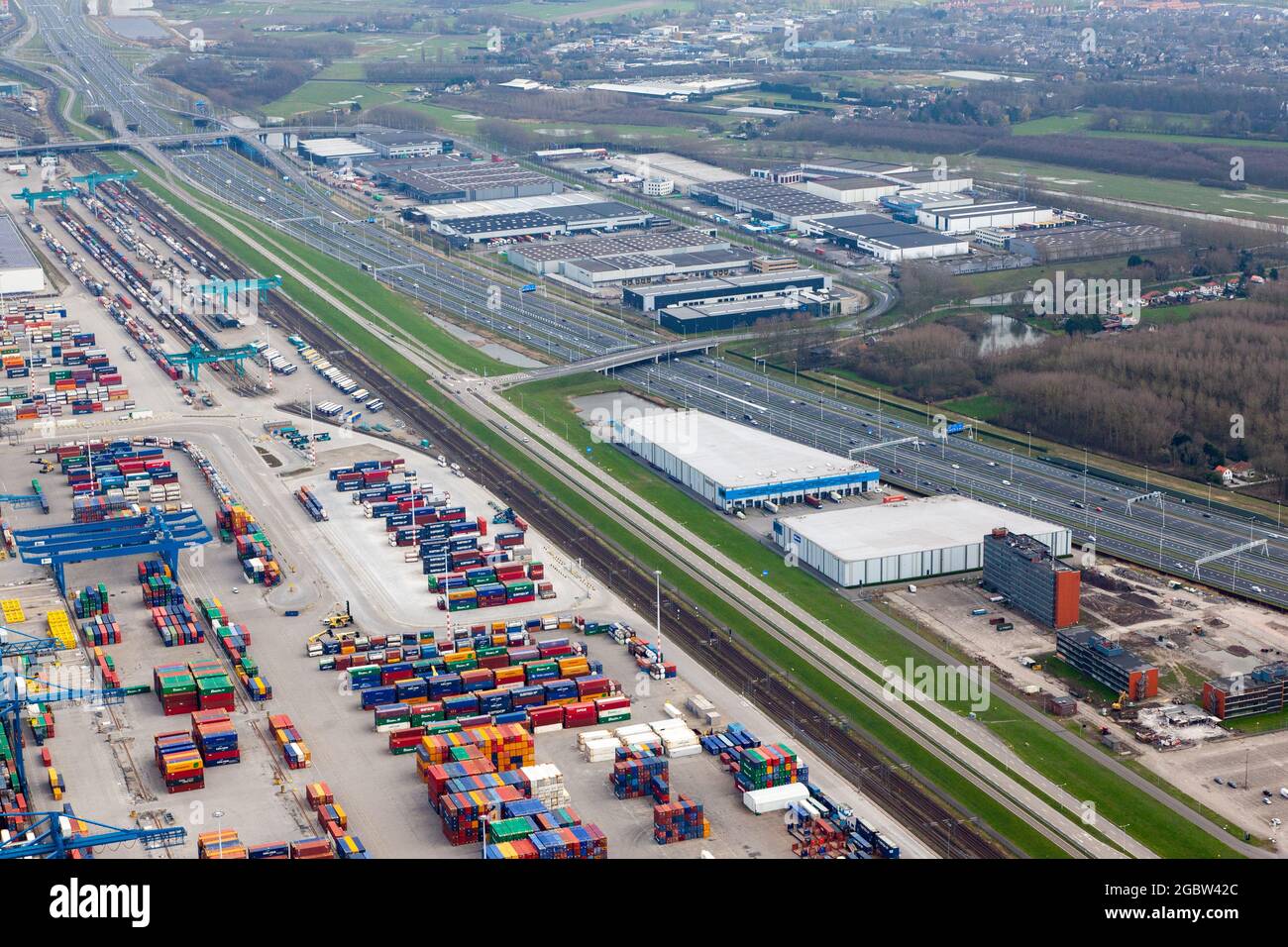 ROTTERDAM, NIEDERLANDE - 02. Aug 2021: Luftaufnahme eines Industriegebiets mit Lagerhäusern, Containerterminal und Autobahn. Stockfoto