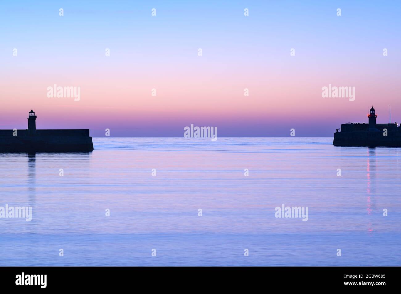 Spektakuläre Aussicht am frühen Morgen auf die Leuchttürme des West- und East Pier des berühmten Hafens von Dun Laoghaire während der blauen Stunde vor Sonnenaufgang, Dublin, Irland. Stockfoto