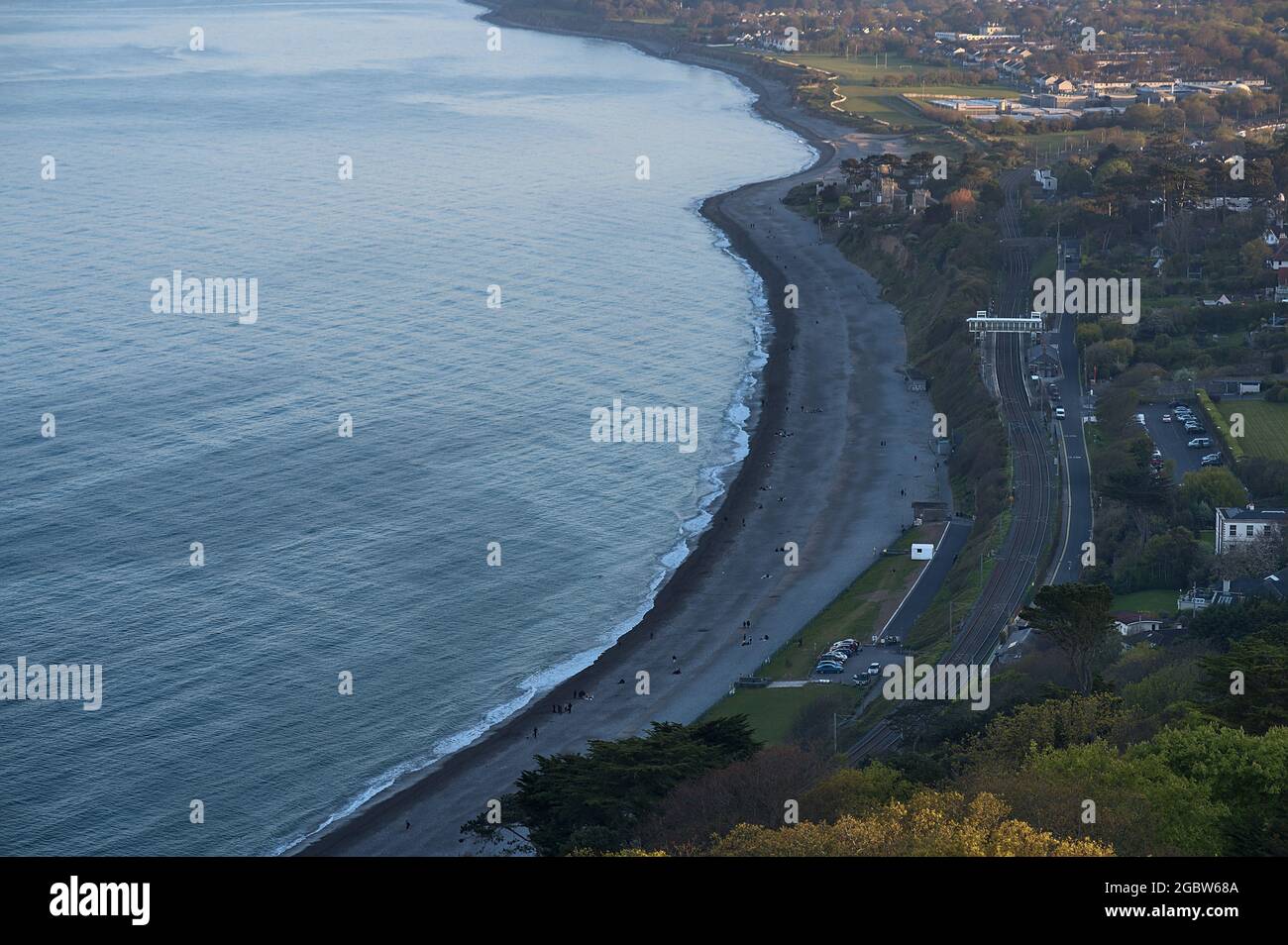 Wunderschöne, luftige Abendansicht von Killiney Beach, Küstenlinie und Eisenbahn vom Killiney Hill während der Golden Hour, Dublin, Irland. Weichfokus Stockfoto