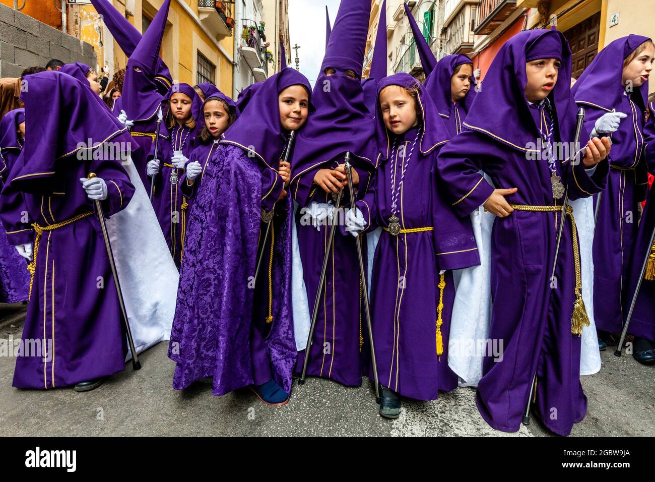 Eine Gruppe von Kindern nimmt an EINER Straßenprozession Teil, Semana Santa (Karwoche), Malaga, Andalusien, Spanien. Stockfoto