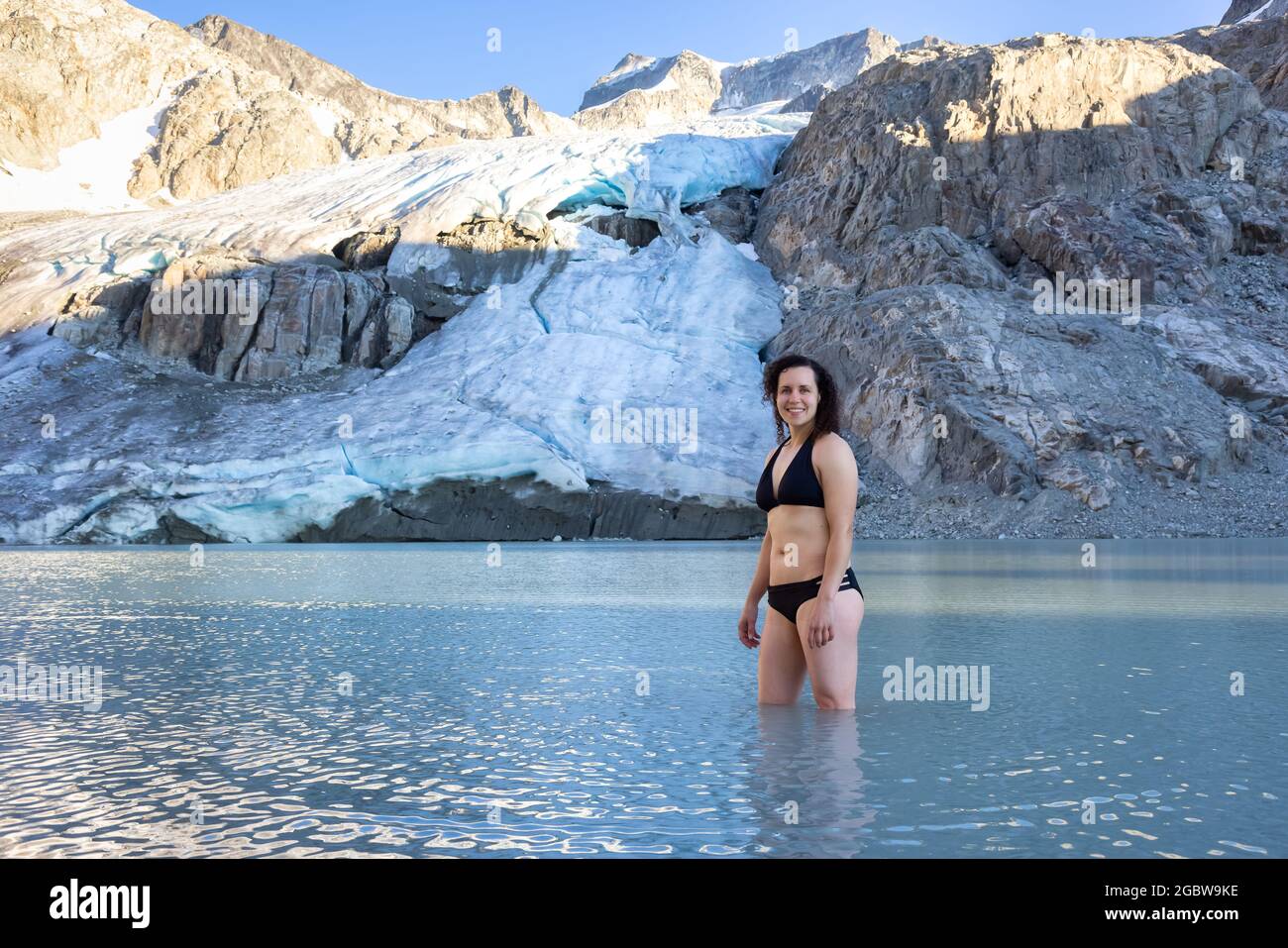 Abenteuerliche weißkaukasische Erwachsene Frau Schwimmen im eiskalter Gletschersee Stockfoto