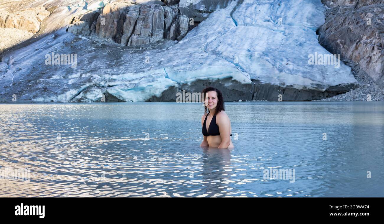 Abenteuerliche weißkaukasische Erwachsene Frau Schwimmen im eiskalter Gletschersee Stockfoto