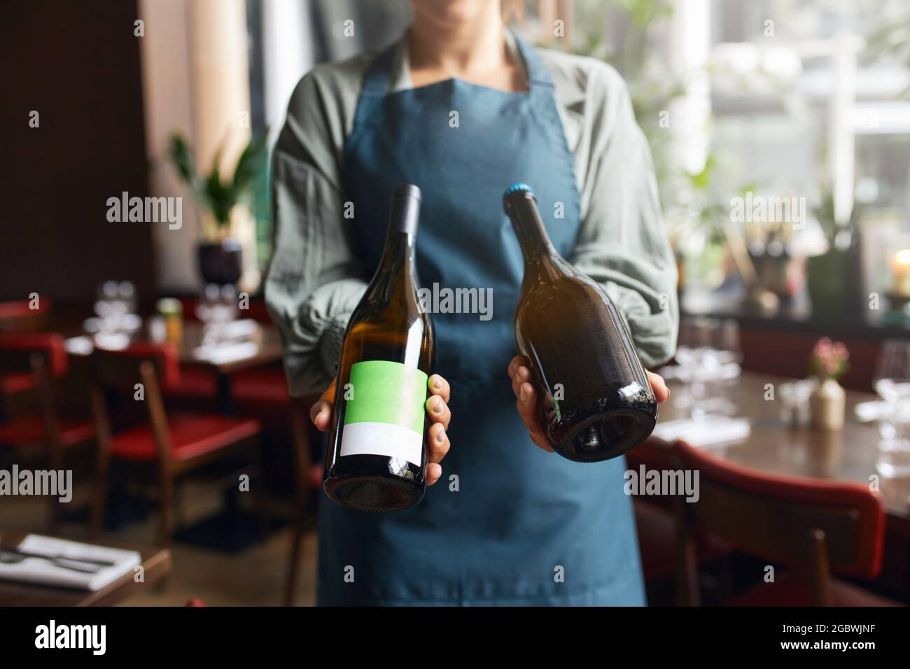 Kellnerin mit Weinflaschen Stockfoto