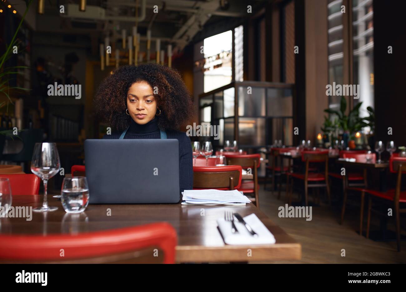 Restaurantbesitzer, der mit einem Laptop arbeitet Stockfoto