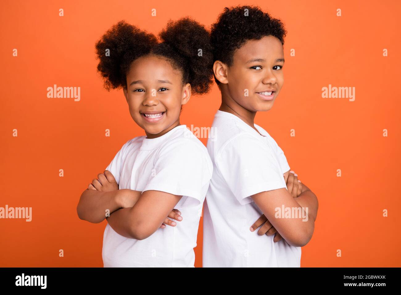 Profilfoto des kleinen lustigen Mädchen Junge gekreuzte Arme tragen weißes T-Shirt isoliert auf orangefarbenem Hintergrund Stockfoto