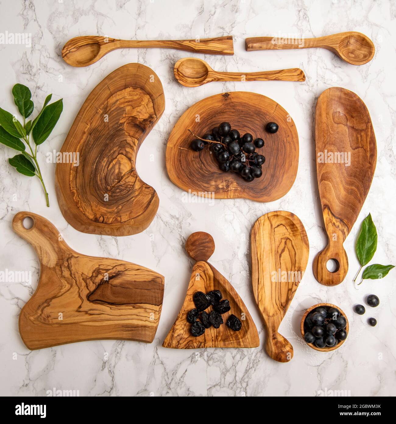 Holzlöffel und Käseplatten mit Trauben Stockfoto