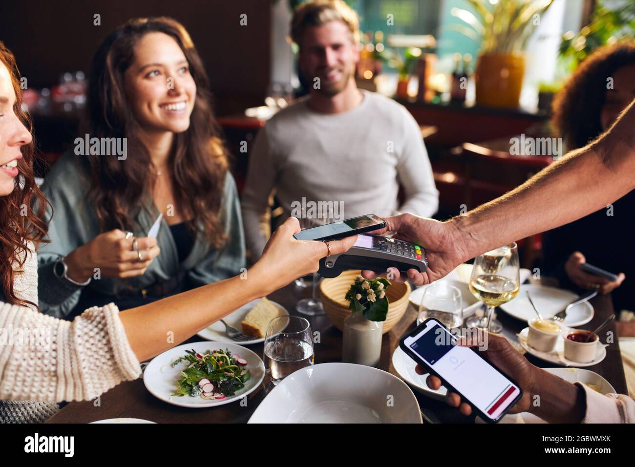 Freunde zahlen kontaktlos im Restaurant Stockfotografie - Alamy