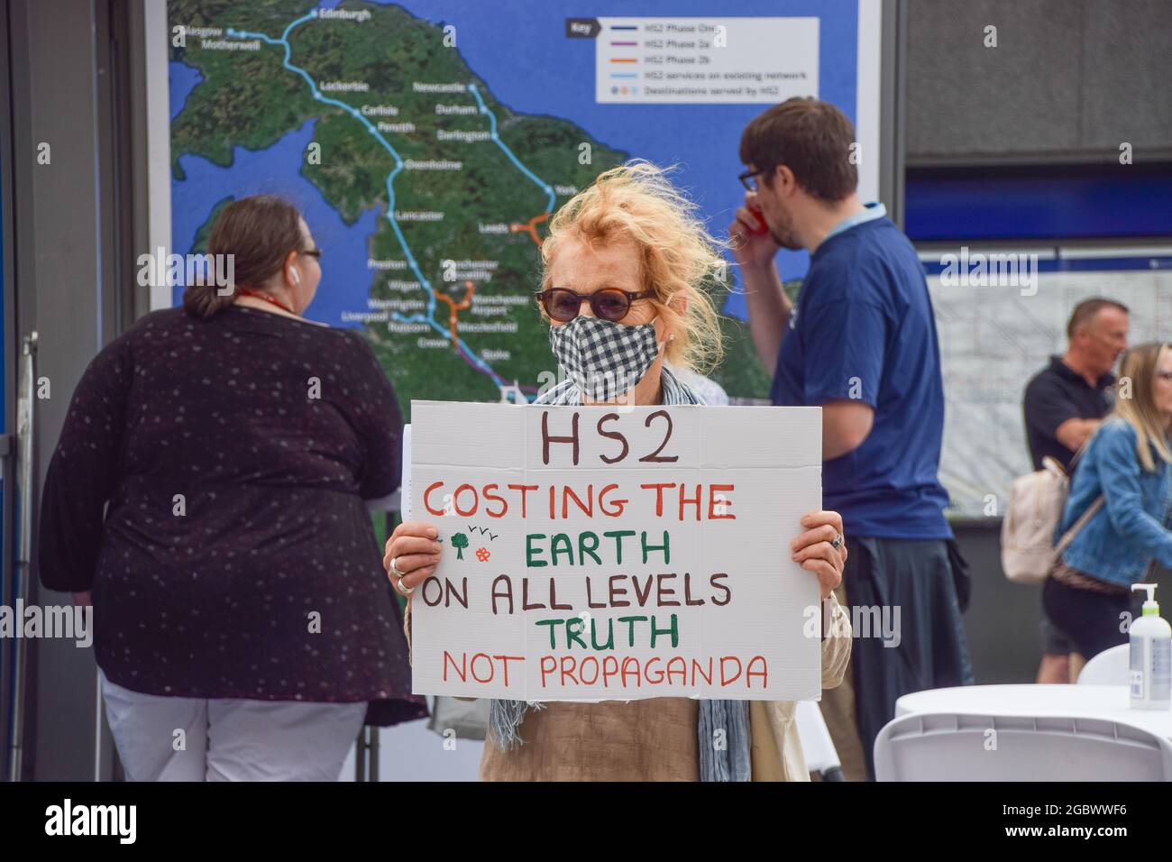 London, Großbritannien. August 2021. Ein Demonstrator hält ein Anti-HS2-Plakat während des Stop HS2-Protests.Aktivisten versammelten sich vor der King's Cross Station, um gegen das neue Hochgeschwindigkeits-2-Eisenbahnsystem (HS2) zu protestieren, das Umweltschützer sagen, dass es "ökologisch verheerend" sein wird und Steuerzahler £170 Milliarden kosten wird. Kredit: SOPA Images Limited/Alamy Live Nachrichten Stockfoto