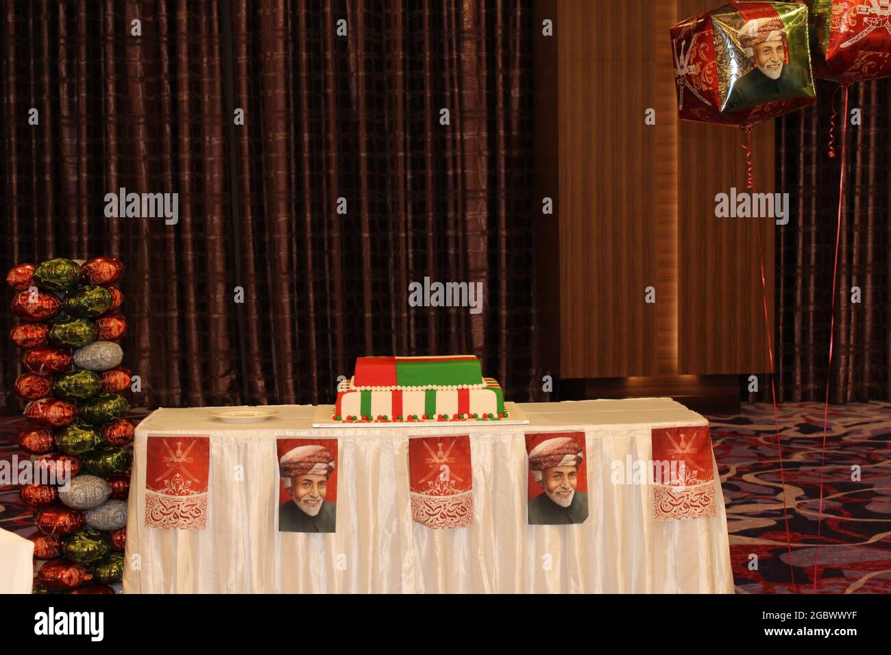 Die Torte des National Day ist fertig mit einem Foto des Oman King, das in einem Fraser Suites Bankettsaal zur Feier geschnitten wird Stockfoto