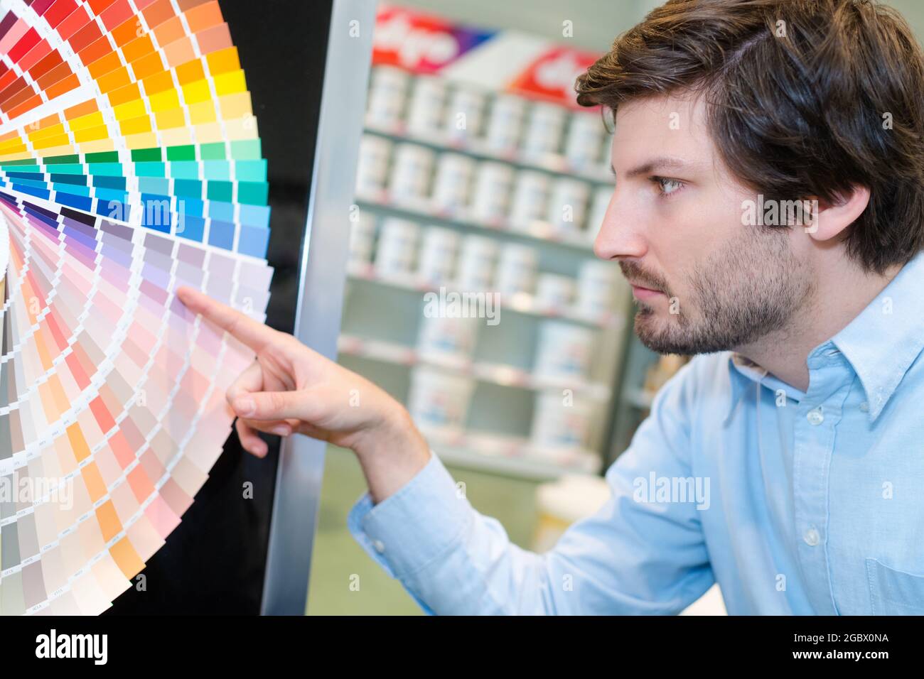 Mann, der auf Farbe auf dem Farbkartenspektrum zeigt Stockfoto