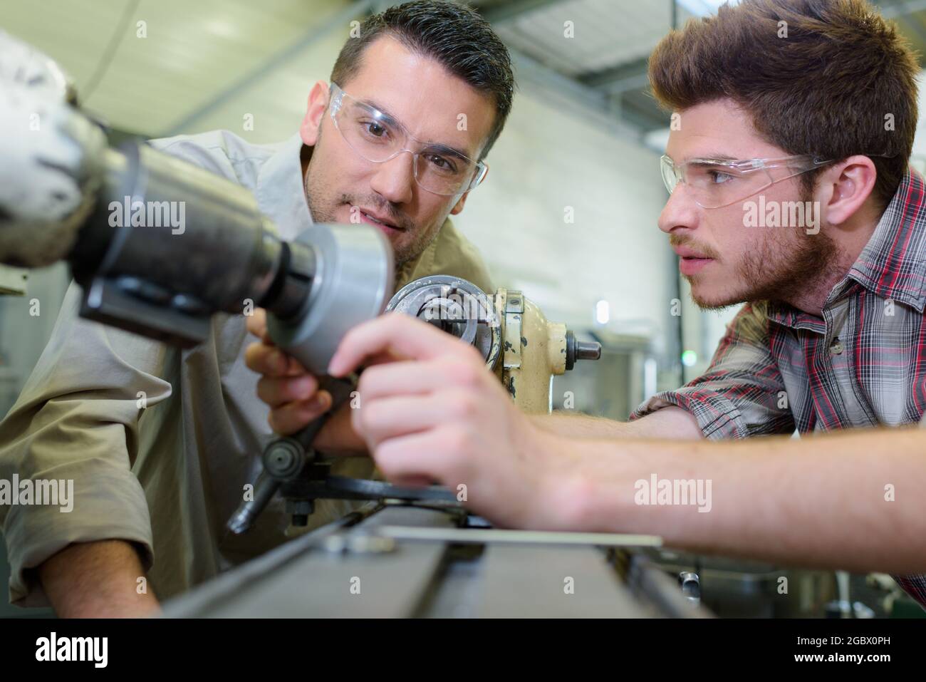 Männlicher Lehrling mit kreisförmigem Bohraufsatz Stockfoto