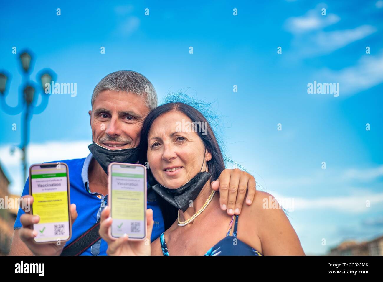 Ein glückliches Paar, das die Stadt mit einem grünen Pass besucht. Mann und Frau sind bereit für eine Reise mit Screenshots der Impfung Stockfoto