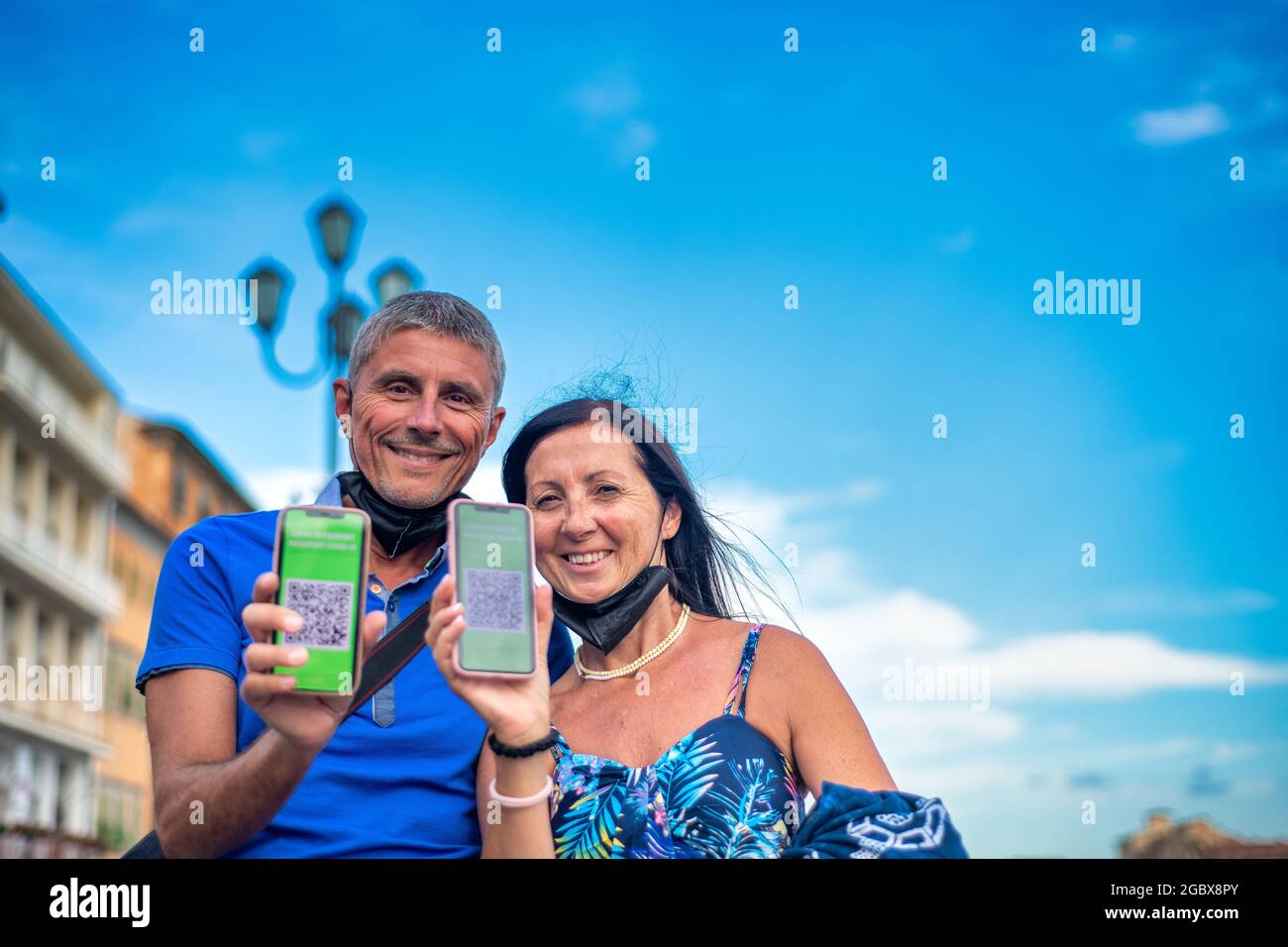Ein glückliches Paar, das die Stadt mit einem grünen Pass besucht. Mann und Frau sind bereit für eine Reise mit Screenshots der Impfung Stockfoto