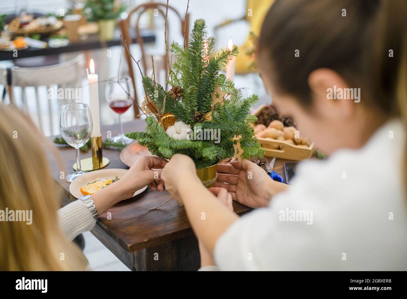 Meisterkurs zum Dekorieren eines Bio-Weihnachtsbaums mit dekorativen Naturelementen und zum Erstellen einer festlichen Komposition. Der Trend zum neuen Jahr ist Null Stockfoto