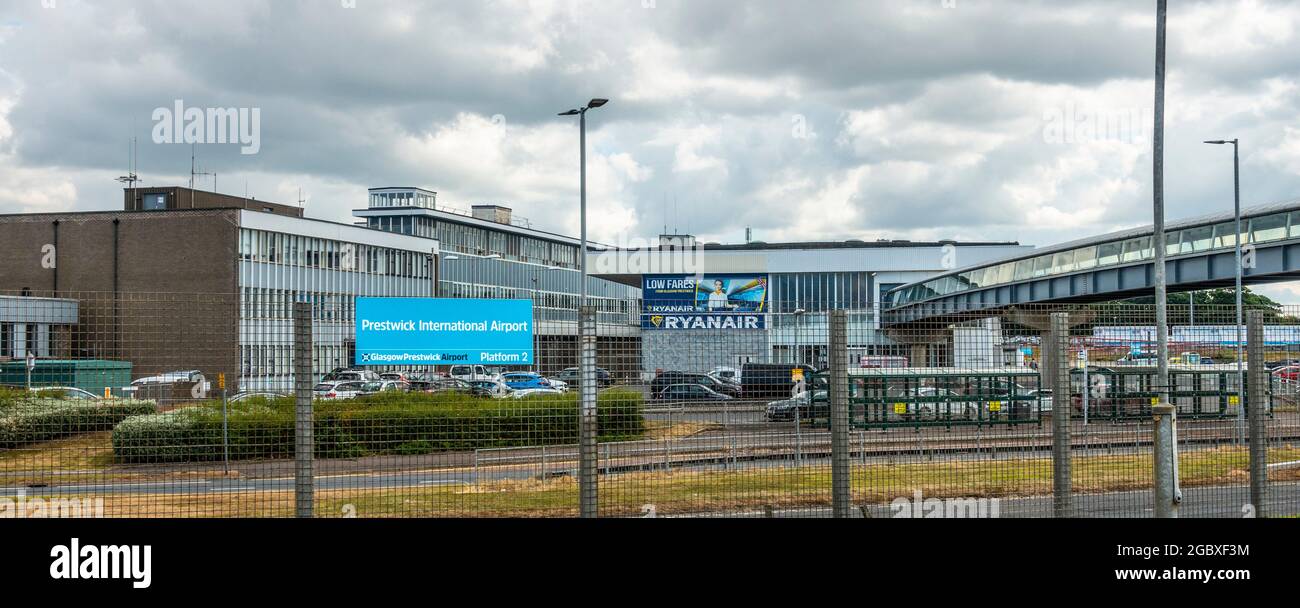 Außenansicht des Prestwick International Airport / Glasgow Prestwick Airport mit Schild. Fußgängerbrücke vom Bahnhof auf der rechten Seite des Fotos. Stockfoto