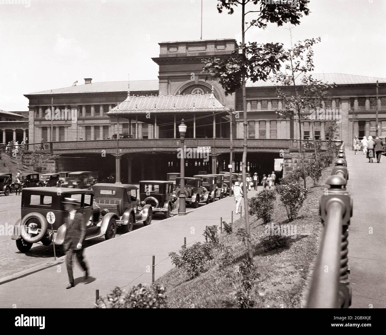 1910ER 1920ER JAHRE BAHNHOF GEGENÜBER POSTAMT PLATZ FUSSGÄNGER UND STRASSE UNTER STATION PROVIDENCE RHODE ISLAND USA - Q19031 CPC001 HARS DAMEN PERSONEN VEREINIGTE STAATEN VON AMERIKA AUTOMOBIL MÄNNER FUSSGÄNGER TRANSPORT B & W GEPARKT NORDAMERIKA NORDAMERIKANISCHEN WEITWINKEL VORBEI UND AUTOS AUSSEN RHODE INSEL VERBINDUNG KONZEPTUELLE AUTOS STILVOLLE FAHRZEUGE RI PROVIDENCE SCHWARZ UND WEISS ALTMODISCHE POST Stockfoto