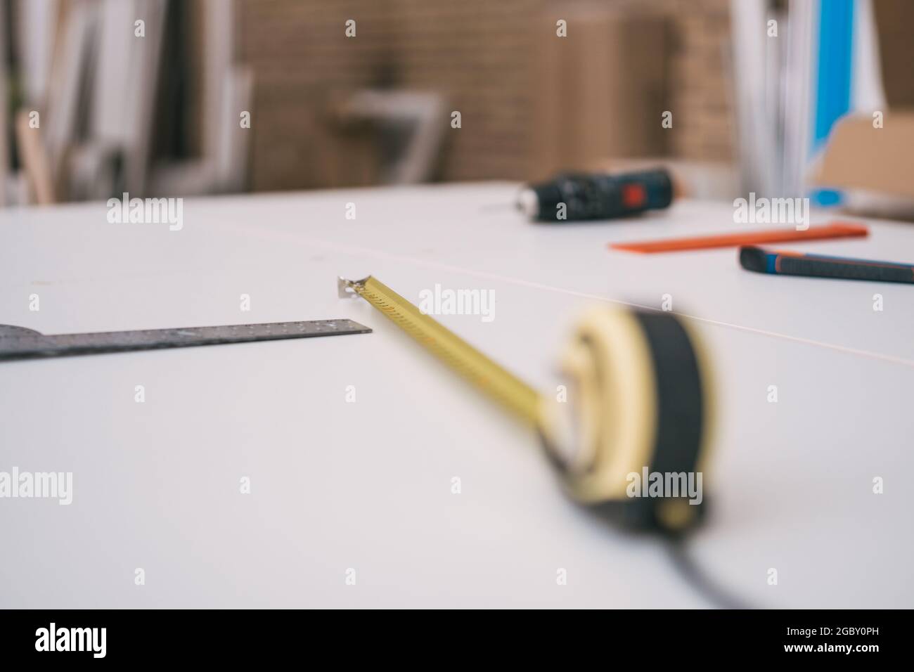 Maßband und Quadrat auf einem weißen Tisch einer Werkstatt Stockfoto