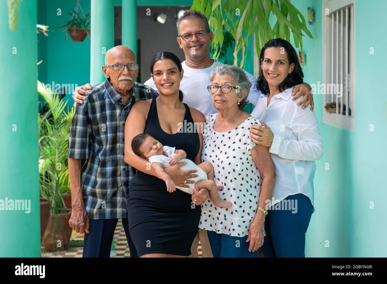 Foto einer Gruppe von Menschen. Ein Baby in den Armen einer jungen Frau, eines Mannes, einer Frau und eines älteren Paares Stockfoto