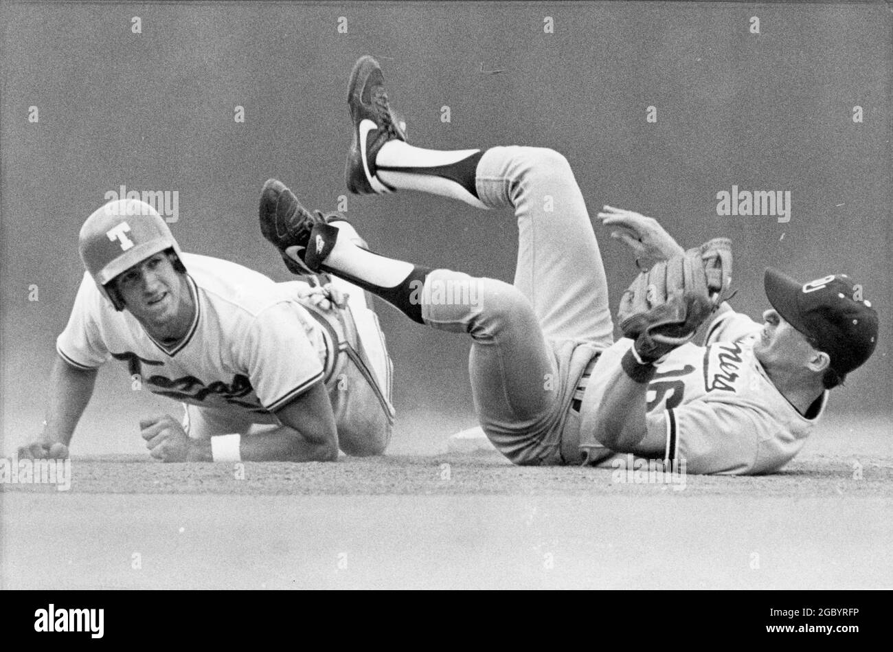 Austin Texas USA< um 1982: Action zwischen dem Baseballteam der University of Texas und den Gegnern auf dem Heimfeld von UT; der Infielder stürzt ab, während der Baserunner in die zweite Basis gleitet. ©Bob Daemmrich Stockfoto