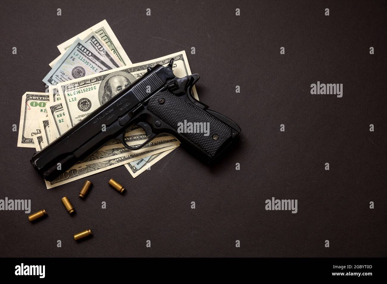 Kriminelles Geld, Mafia- und Korruptionskonzept, Kriminalkonzept, Pistolenhandgun 9 mm und amerikanische Dollar-Banknoten auf schwarzem Hintergrund. Stockfoto
