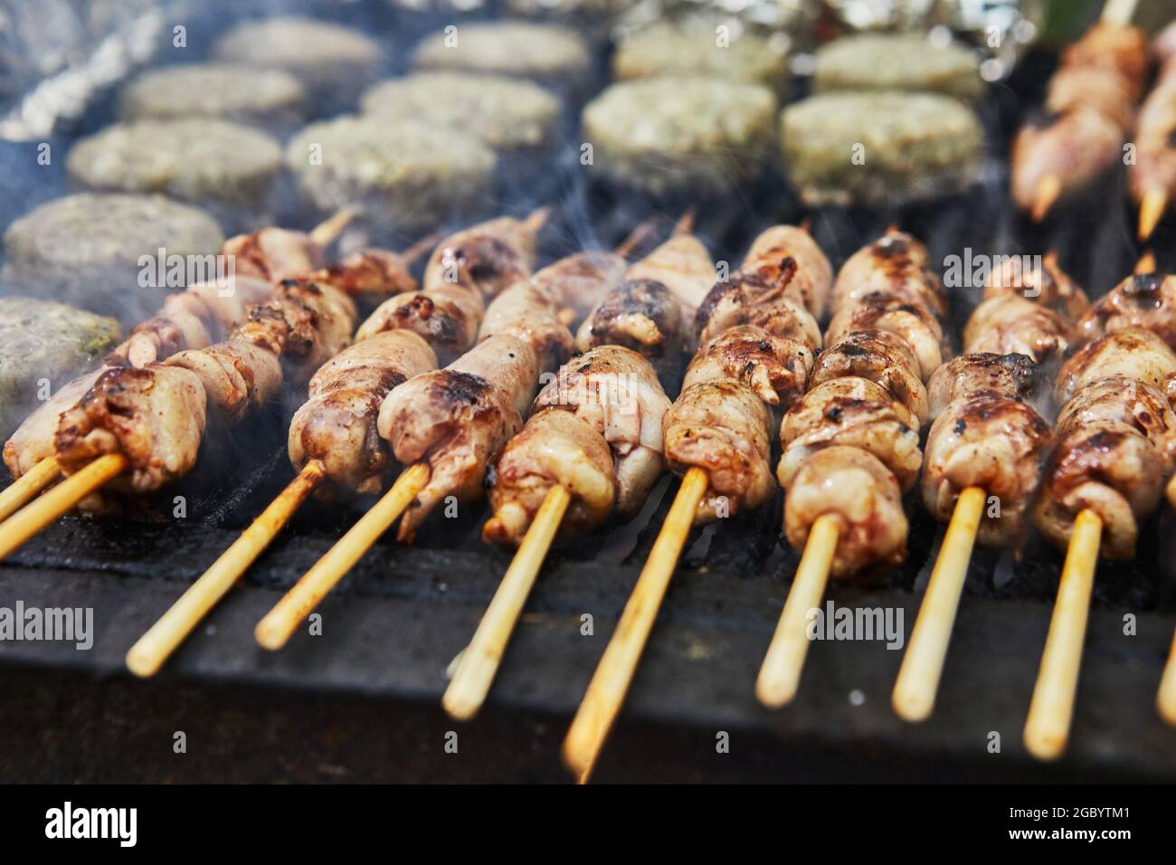 BBQ Burger, gegrillte Herzen auf Spieße und Rauch Grillparty. Nahaufnahme. Stockfoto