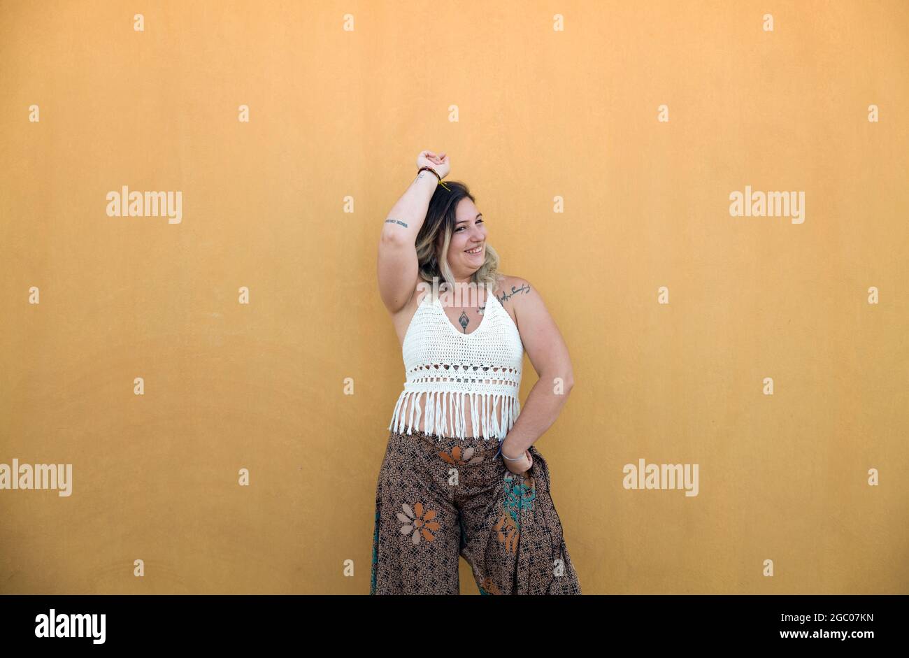 Fröhliches spanisches Mädchen tanzt Flamenco an der gelben Wand Stockfoto