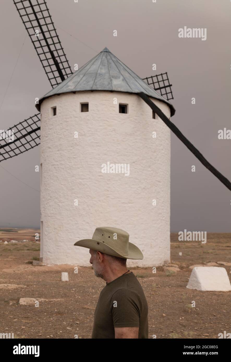 Ein Mann mit Cowboyhut und Windmühlen auf dem Land Stockfoto