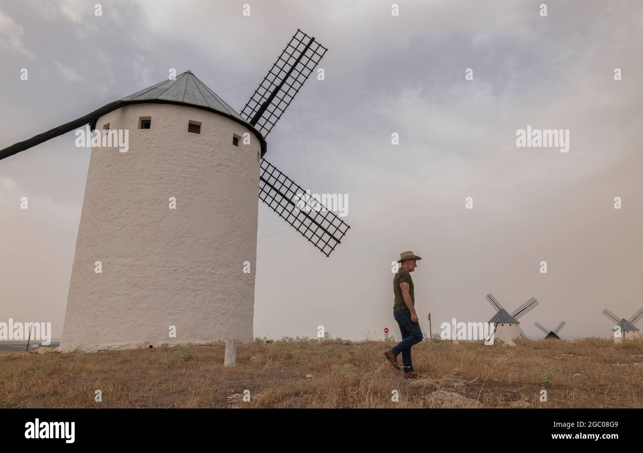 Ein Mann mit Cowboyhut und Windmühlen auf dem Land Stockfoto