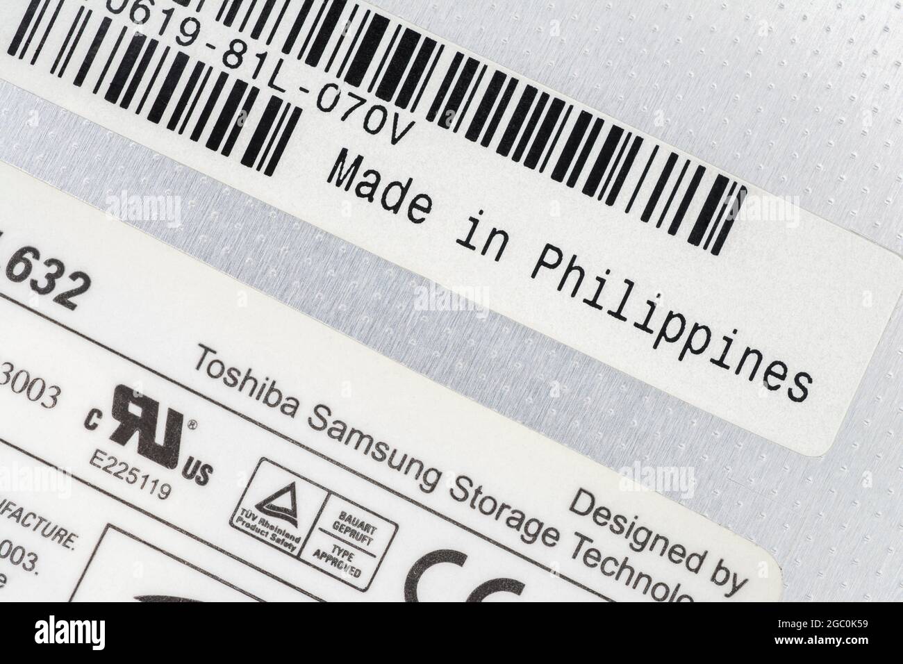Papieretiketten auf der Rückseite eines von Toshiba-Samsung hergestellten DVD-Schreibers für Laptops mit Etikett „Made in the Philippines“. Zum Offshoring von Teilen. Stockfoto