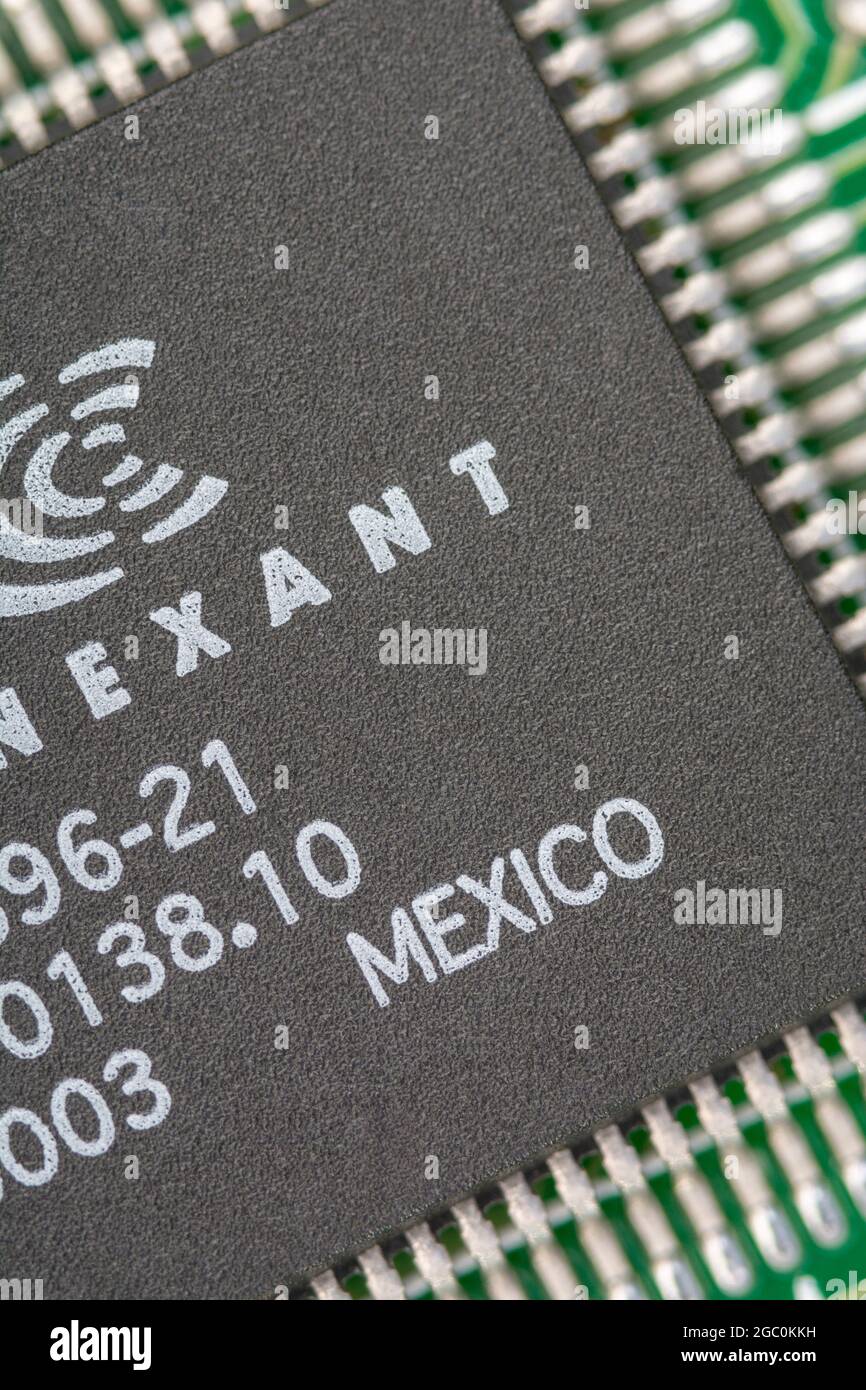 Makroaufnahme eines Mikrochips aus Mexiko auf einer alten Modemkarte mit sichtbaren Reihen von Pinouts. Chip von Conexant. Stockfoto