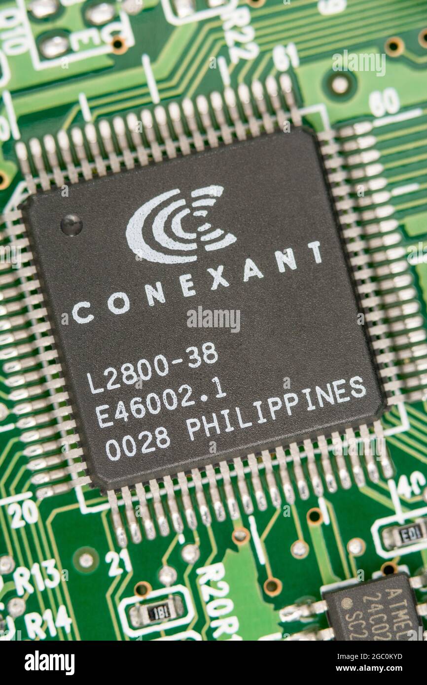 Makroaufnahme eines Mikrochips, der auf den Philippinen auf einer alten Modemkarte hergestellt wurde, mit sichtbaren Reihen von Pinouts. Chip von Conexant. Stockfoto