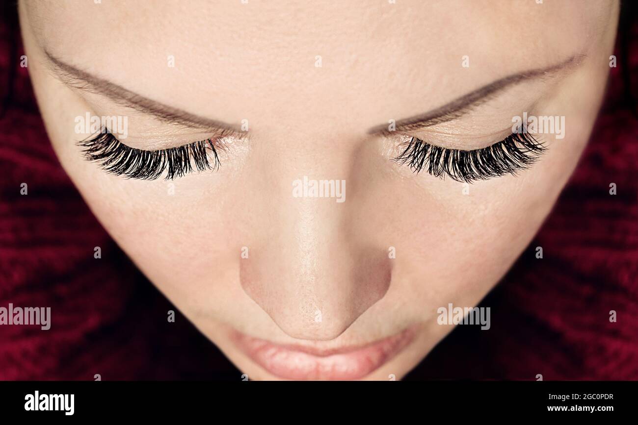 Wimpern Verlängerung Verfahren. Nahaufnahme der Augen der Frau mit langen falschen Wimpern. Draufsicht. Stockfoto