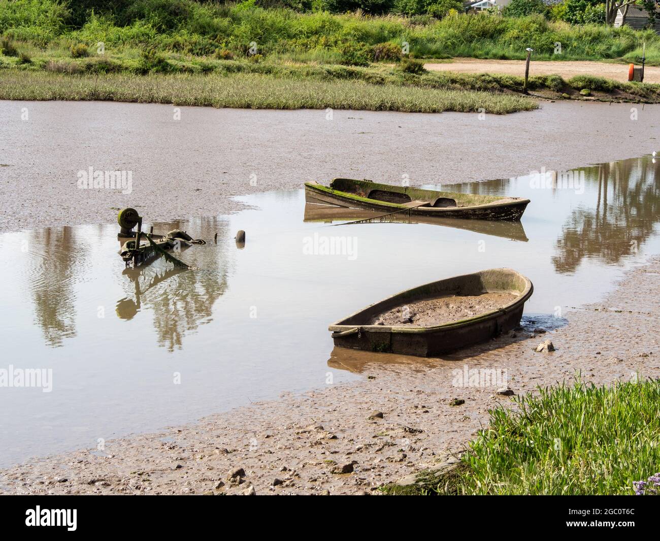 Zwei alte versunkene Boote in einer Gezeitenlagune, Brancaster Staithe, Norfolk, Großbritannien Stockfoto
