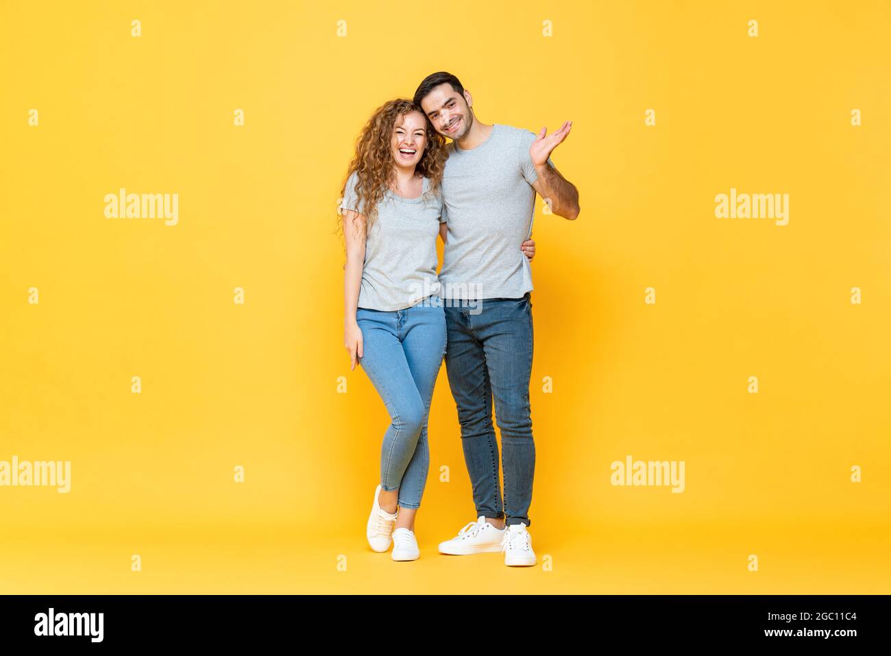 In voller Länge Porträt von jungen glücklich interracial paar in isolierten gelben Studio Hintergrund Stockfoto