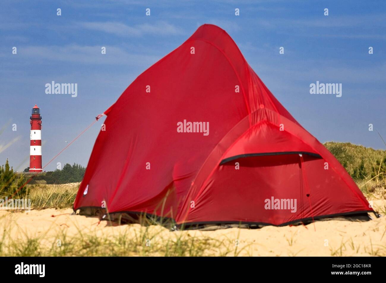 Rotes Zelt in den Dünen, Amrum-Leuchtturm im Hintergrund, Deutschland, Schleswig-Holstein, Amrum Stockfoto