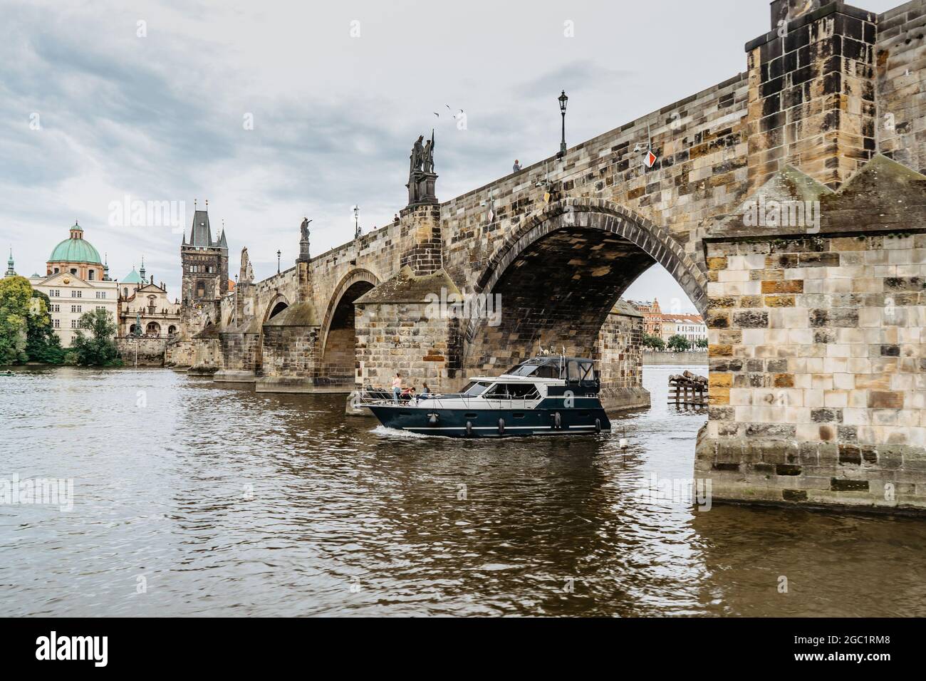 Karlsbrücke, Luxusboot auf der Moldau, Prag, Tschechische Republik. Gebäude und Wahrzeichen der Altstadt am Sommertag. Beeindruckender europäischer Stadtklanglauf. Stockfoto